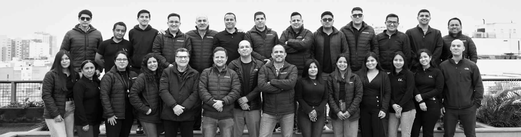 Equipo de Frontera Inmobiliaria, expertos en Departamentos en Venta en Lima, posando en una terraza urbana.